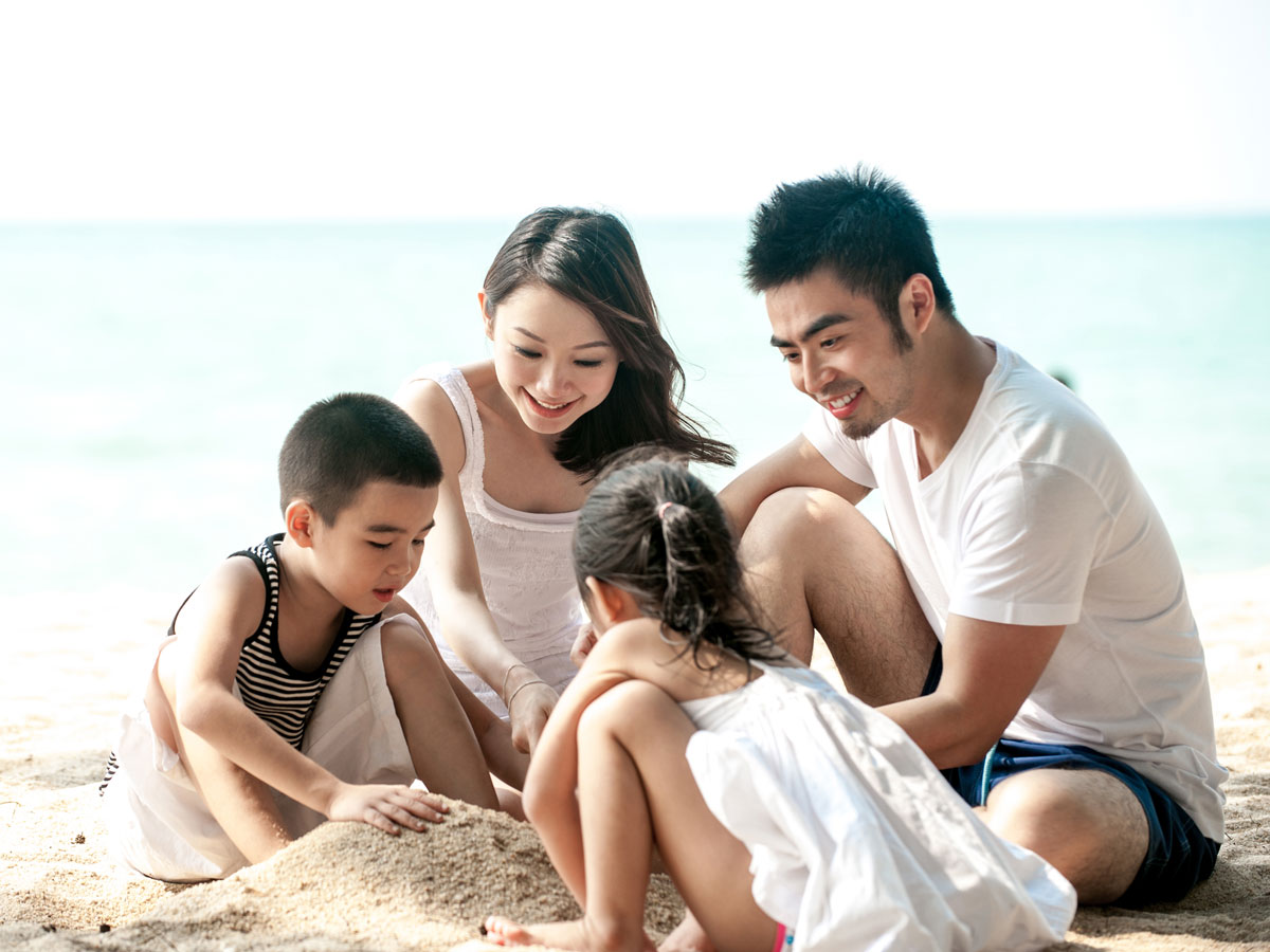 Family on beach building a sandcastle